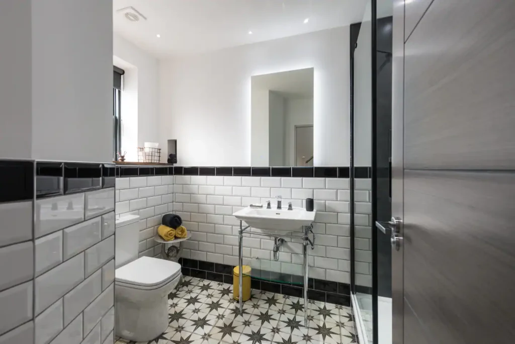 Modern bathroom with white subway tiles, patterned floor, and sleek fixtures.