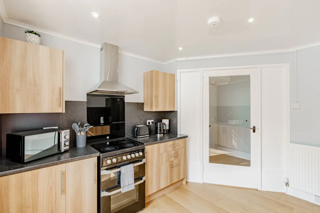 Modern kitchen with light wood cabinets, stainless steel appliances, and a sleek countertop.