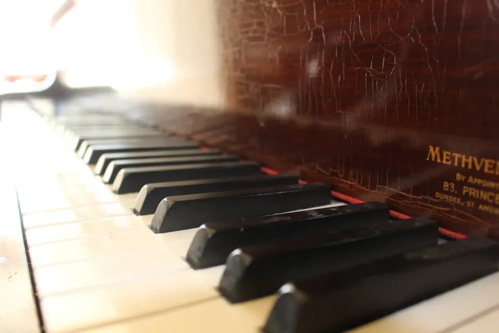 Close-up of vintage piano keys, highlighting the elegant wooden finish and detailed craftsmanship.